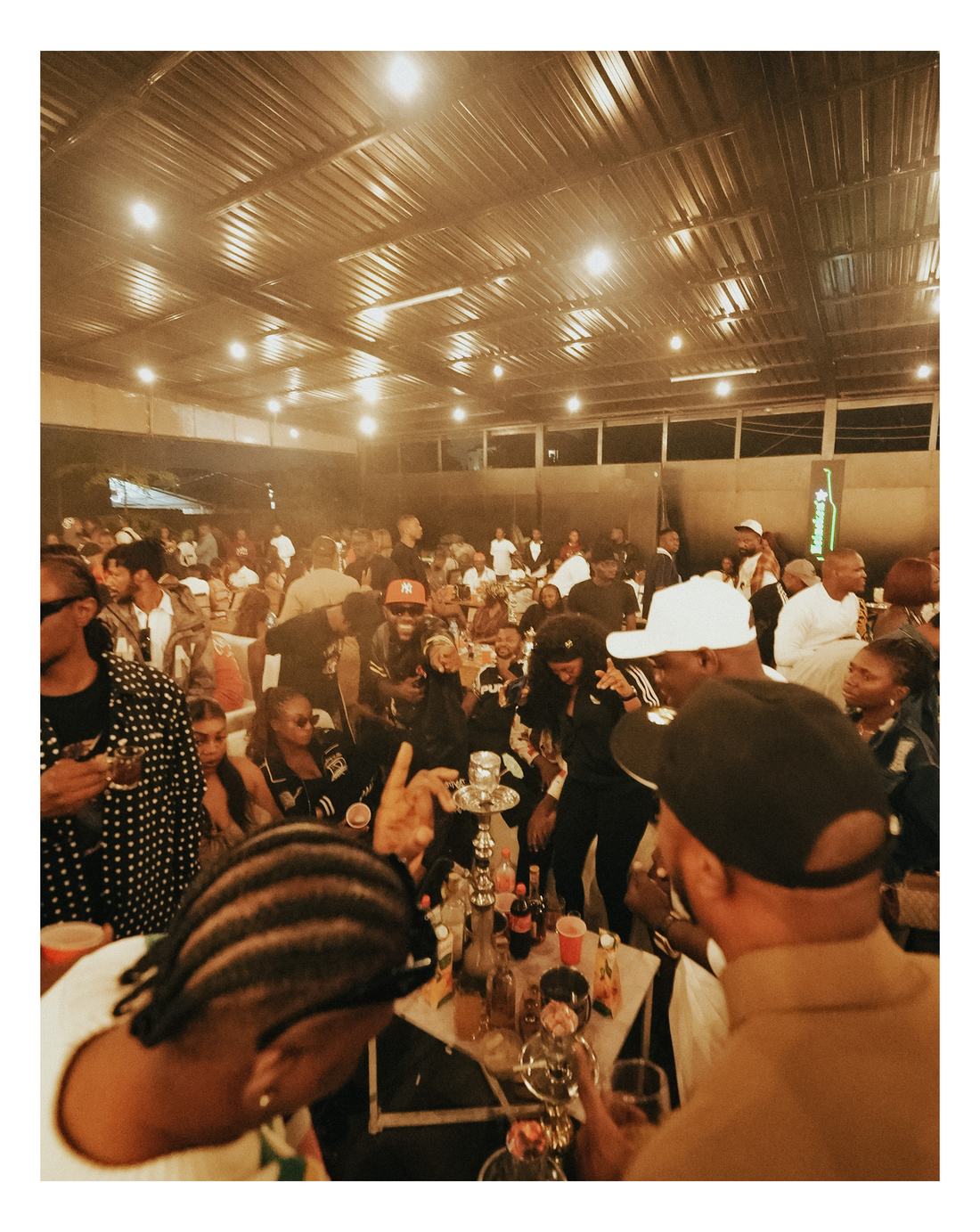 Crowd gathered around a lounge table with shisha at Romie's Block